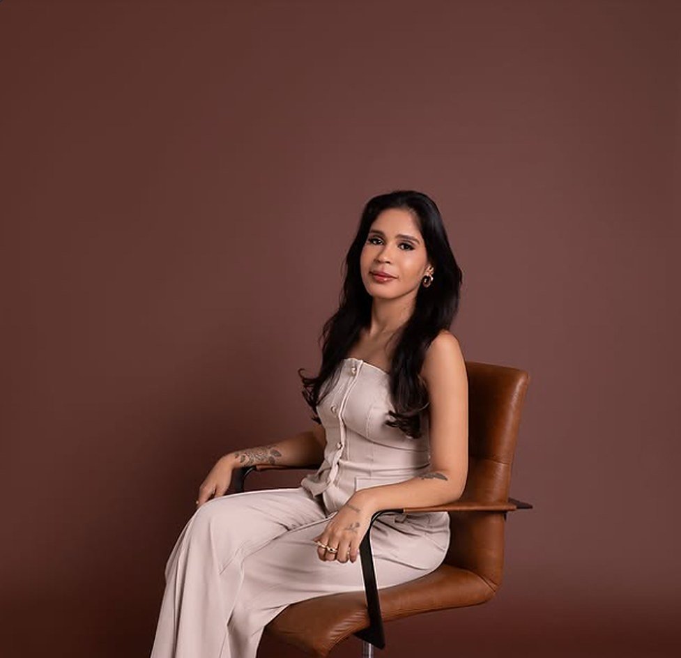 Dra. Hanna Chites sentada em cadeira de couro, em ensaio de estúdio